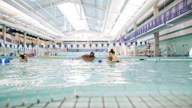 Parents teaching tots to swim at Pullen Park Pool